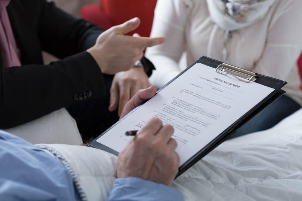 Close-up of older sick man holding his last will and testament