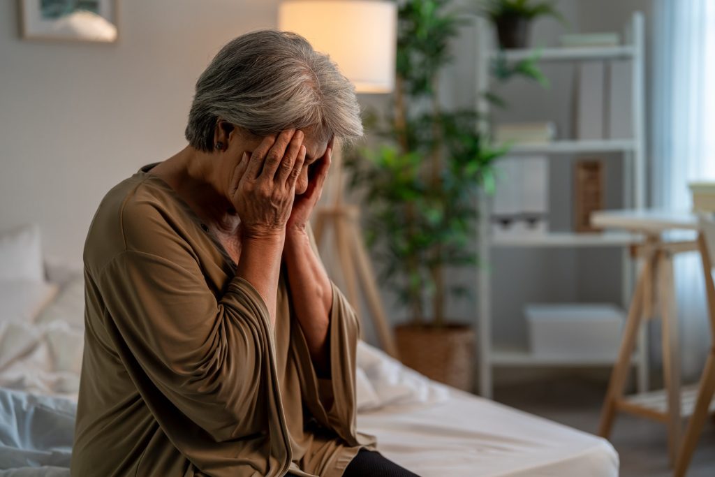 senior elderly depressed woman sitting alone in bedroom at home Attractive mature grandmother feeling sad lonely and frustrated